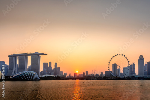 Singapore skyline at sunset with Marina Bay Sands, Singapore Flyer, and city reflected in the calm bay