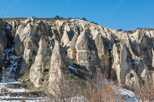 Panoramic landscape view across rural countryside Goreme valley during winter in Cappadocia Central Anatolia Turkey with geological fairy chimney rock formations and snow
