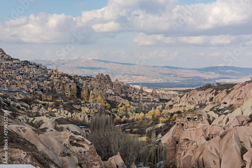 Panoramic landscape view across rural countryside valley during winter in Cappadocia Central Anatolia Turkey with geological fairy chimney rock formations and snow