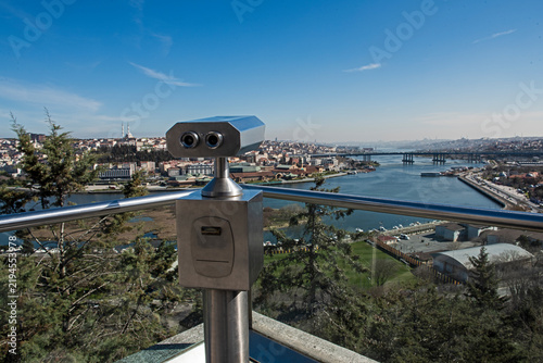 Closeup detail of binoculars on a viewing platform overlooking large Bosphorus river and Istanbul Turkey from famous Pierre Loti Cafe panorama landscape
