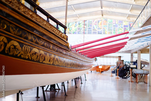 Bild auf Leinwand A historical wooden boat with ornate carvings displayed in a museum setting