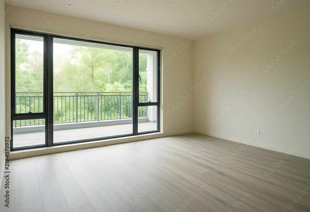 Fototapeta premium Real estate and home staging, empty modern apartment interior with large windows and balcony overlooking green trees in a quiet residential neighborhood