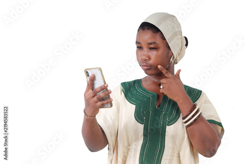 African woman pensively looking at her phone, hand on her chin