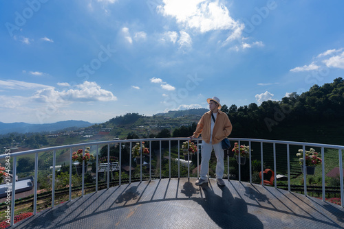 Fotografía A tourist stands at a mountain viewpoint, gazing at the skyline scenery at Mon Jam, Chiang Mai, Thailand