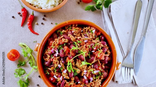 chili con carne with kidney beans minced beef rice and chili peppers on table
