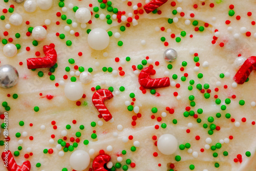 Christmas Frosting Background with Red and Green Sprinkles and Candy Canes Close Up