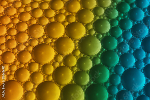 Obraz na płótnie Close-up bubble clusters transitioning through vibrant rainbow colors in gradient lighting