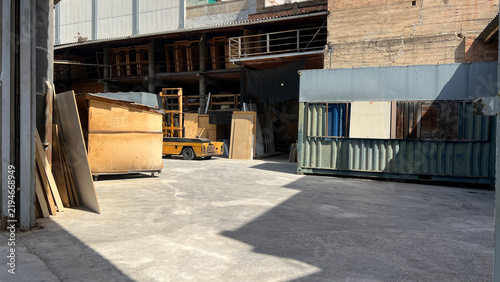 Yellow Forklift Parked in Industrial Warehouse Storage Area. Industrial Warehouse Interior with Forklift and Storage Structures.