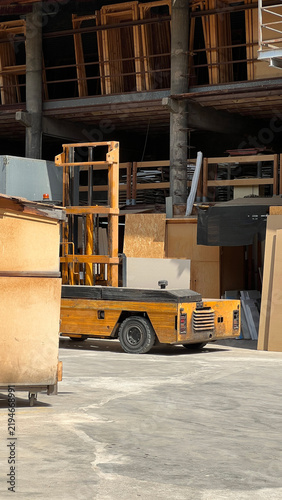 Yellow Forklift Parked in Industrial Warehouse Storage Area. Industrial Warehouse Interior with Forklift and Storage Structures.