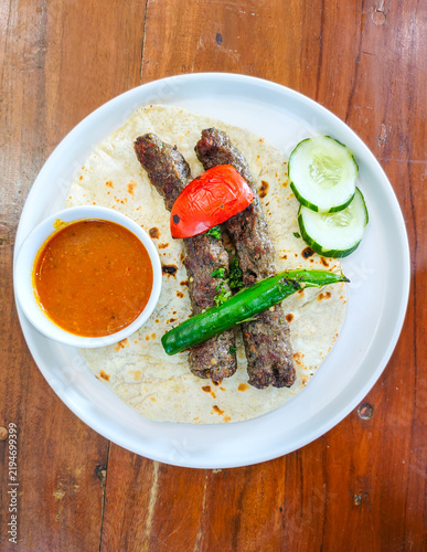 Принти на полотні Traditional Middle Eastern minced meat shish kebab or kofta on lavash bread with cucumber slices, chili, and dipping sauce