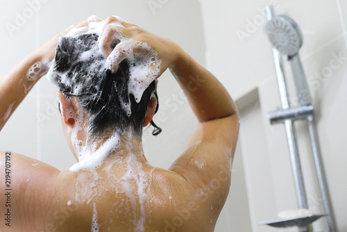 Woman is washing her hair with shampoo.	