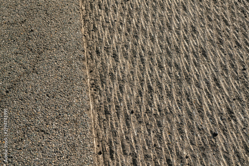 Milled asphalt road surface texture next to freshly laid smooth pavement, roadwork construction site with traffic safety cones, urban street resurfacing, infrastructure repair, selective focus