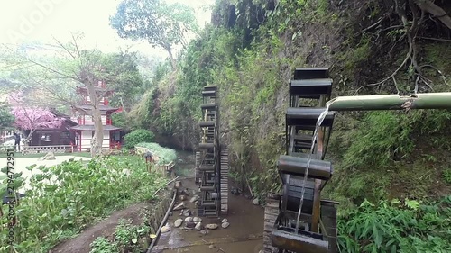 Static view of traditional water wheel in river stream and nature landscape