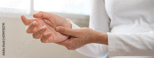 Fotografie Health care and medical concept, rheumatism asian woman hand pain from cramp, trigger finger, wrist pain touching massaging, hand holding ache joint, arthritis inflammation