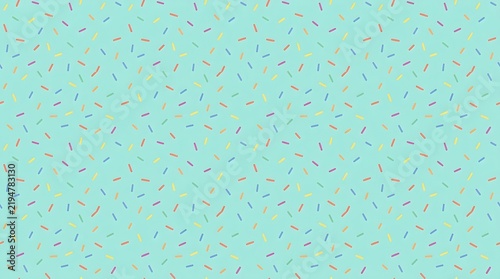 Light blue background, with a scatter, of small, colorful, sprinkles abstract candy celebration