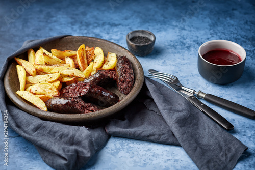 Obraz na plátně Blood sausage and potato wedges serving with sauce