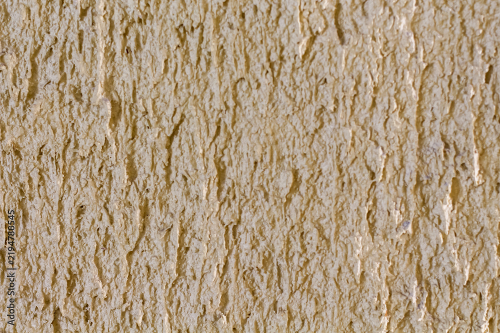 Fototapeta premium Close-up textured background of a rough, sandy beige stucco wall surface