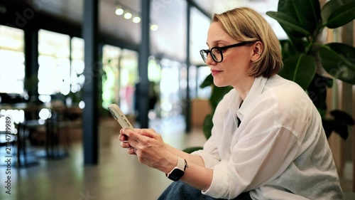 Professional Woman Using Smartphone In Modern Coworking Space During Casual Office Break