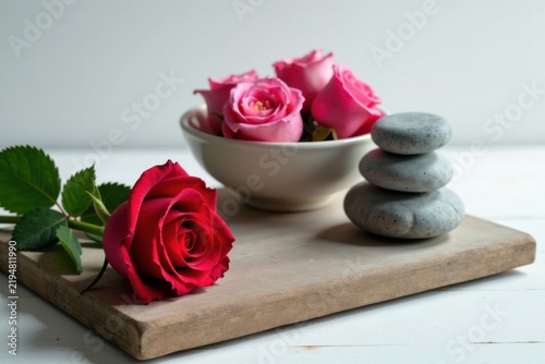 Serene Spa Still Life Pink and Red Roses with Stacked Stones on Wooden Board