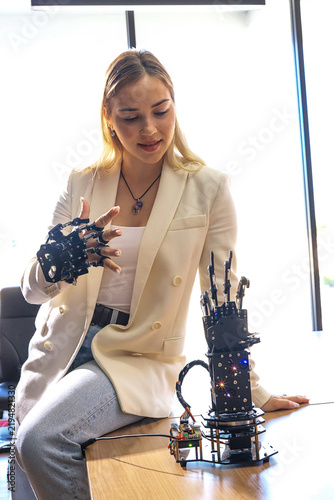  Female student of robotic working on project. Female engineer at conference project meeting room, discuss and inspect robot AI mechanism, find solutions, use laptop at industrial technology factory. 