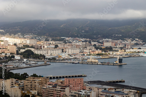 Panoramic high angle view of the Port of Ceuta and city waterfront under cloudy sky