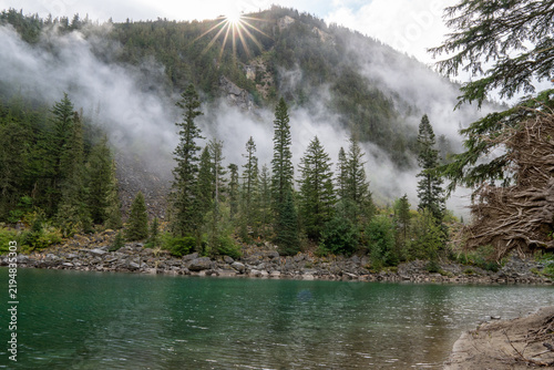 Incredible sunrise over a lake with mountains and a Canadian pine forest.