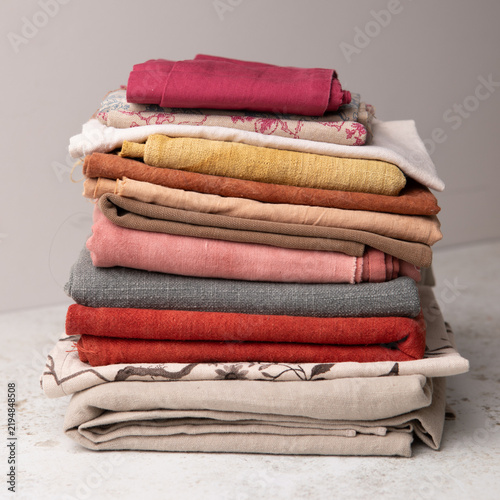 Close-up of a stack of folded colourful fabric samples and textiles on a table