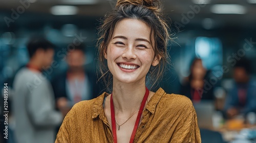 Young woman smiling with eye closed in a lively indoor social setting