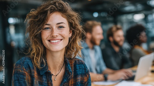 Smiling young woman with curly hair in a professional group setting at work