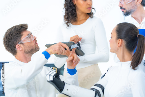 Картината върху платно Robotic hand calibration underway as an engineer aligns a black interface module