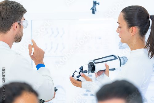 Obraz na płótnie Robotic hand calibration explained at a schematic wall, an engineer holding up h