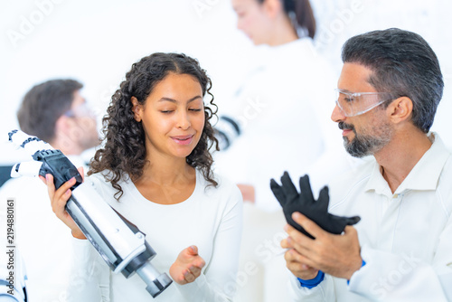 Fotografía Haptic feedback engineering with a smiling researcher lifting a black bionic for