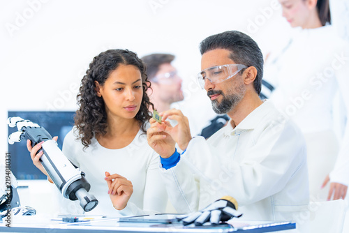 Foto Haptic feedback engineering as two researchers hold a miniature tactile sensor u