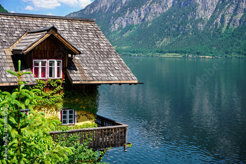 A close-up of a traditional charming wooden Hallstatt lakeside house in front of dreamy view of the lake and mountains.