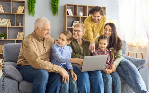 фотографія Multigenerational family grandparents parents children smiling using laptop