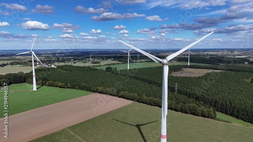 vue aérienne panoramique dans un parc éolien en Belgique, près de Bastogne et du village de Sibret. Les éoliennes sont entourées de champs agricoles ou de prairie pour l'élevage des bovins. 