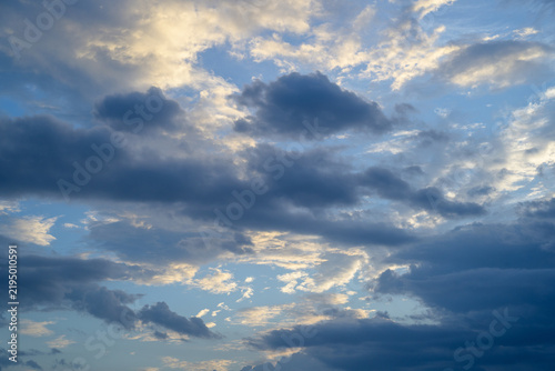 Dramatic sky view showing dark cloud formation and peaceful sunlight during scenic atmospheric sunset with dramatic weather mood