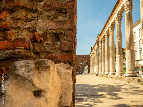 Canvastavla an ancient red-brick wall in the foreground, with the ancient Roman colonnade of