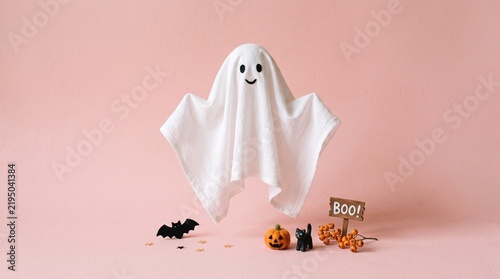Minimalist ghost‑like figure formed by draped white sheet on pink background, playful surreal composition with whimsical Halloween vibe.