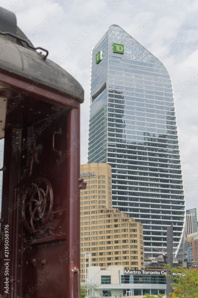 Obraz premium historic passenger wagon at Roundhouse Park and a distant view of Metro Toronto Convention Centre, Intercontinental hotel, and TD Terrace