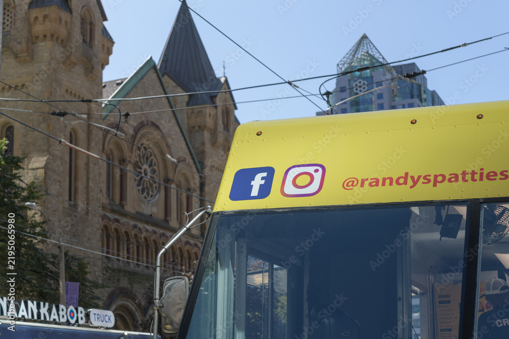 Obraz premium detail of a Randy’s Patties, a Toronto Jamaican patty food truck at a TIFF 2026 activation with defocused St Andrew's Presbyterian Church, King St W and Simcoe St