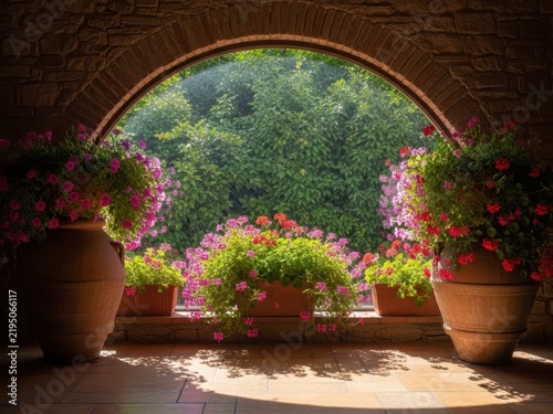 Lush indoor garden with flowering plants under arched structure