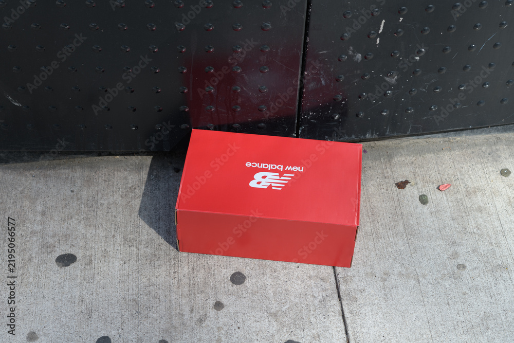 Obraz premium discarded NB (New Balance) footwear box on a sidewalk near a recycling bin in Toronto