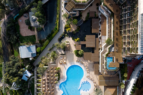 View of a luxury hotel complex with swimming pool, gardens, and sun loungers in Limassol