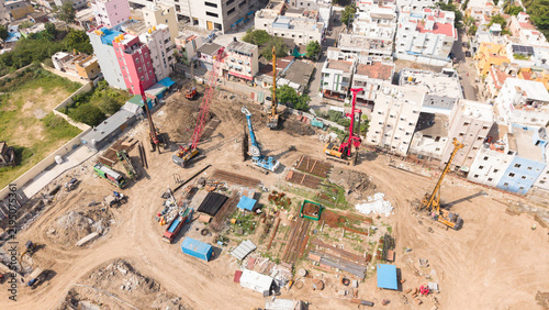 Urban building construction site with cranes and machinery in a dense city real estate development