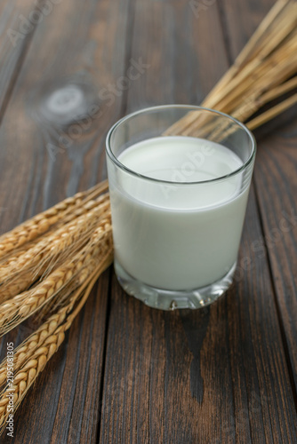 Glass of Fresh Milk with Wheat on Rustic Wooden Table for Healthy Lifestyle Concept