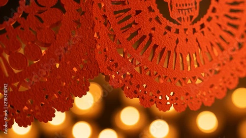 Deep Orange Papel Picado Skull Decoration with Warm Candle Bokeh