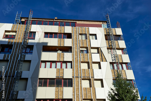upward view of apartment building facade with insulation panels and scaffolding