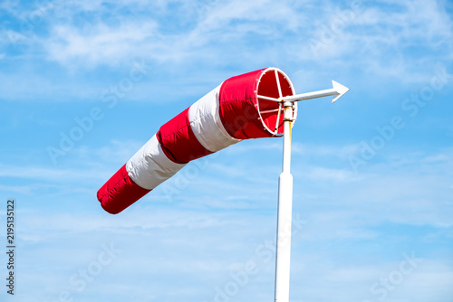 Quadro su tela Red and White Windsock Against a Blue Sky