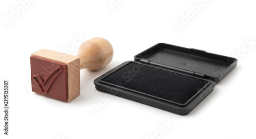 Rubber Stamp and Ink Pad: A wooden rubber stamp with a checkmark imprint lies next to an open ink pad, ready for use in approval and verification tasks.